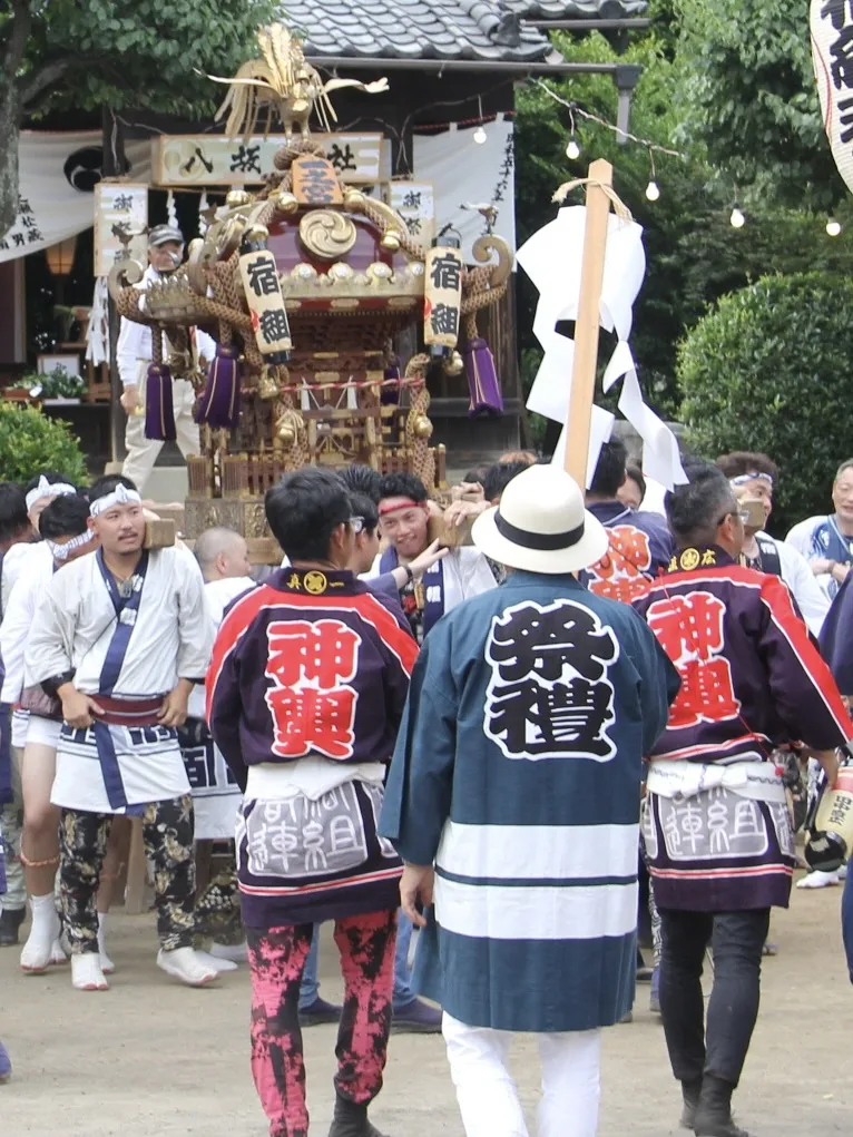 神輿の前に集まった、団体ごとに柄の違う半纏姿の人たち